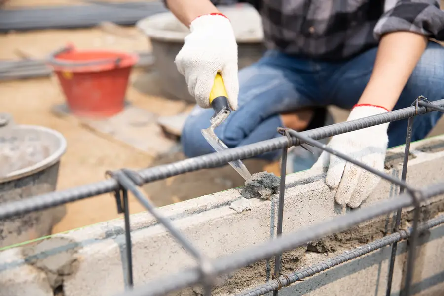 bricklayer-worker-installing-brick-masonry-exterior-wall-with-trowel-putty-knife การเลือกวัสดุก่อสร้าง