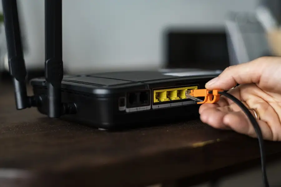 man-plugging-ethernet-cable-wireless-router รีเซ็ต Router